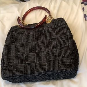 Black basket weave purse with gold detailing.